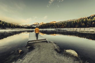 Young woman at Lake Staz near Sankt Moritz in the Engadine in Switzerland. Morning atmosphere with