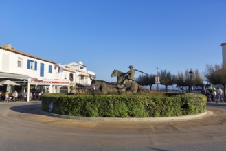 Roundabout with sculptures, cattle herder, guardian of the Camargue on a horse, next to a bull,
