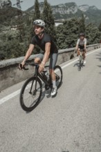 Woman and man riding racing bikes in Italy on Lake Garda
