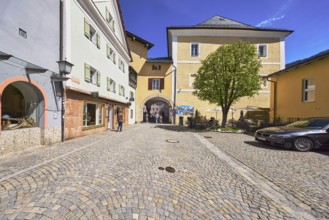 Historic buildings, square, cobblestones, lantern, tree, archway, pedestrian as secondary motif,