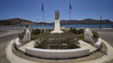 War memorial, circular memorial with sea view, surrounded by two flags and a mountainous