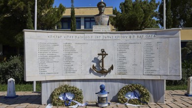A monument with bust and anchor in the centre, surrounded by plaques with inscriptions and wreaths,