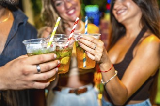 Friends enjoying refreshing cocktails together at a lively summer party, celebrating and having a