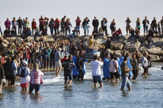 Pilgrimage, procession by the sea, pilgrims walking through water, statue of the Virgin Mary,