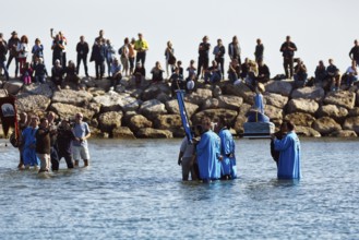 Pilgrimage, procession by the sea, pilgrims walking through water, statue of the Virgin Mary, crowd