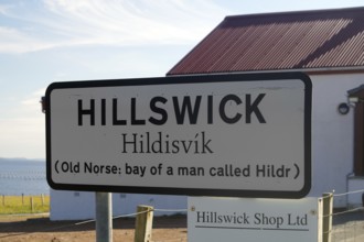Hillswick town sign in front of a building with historical reference to Old Norse names, Eshaness,