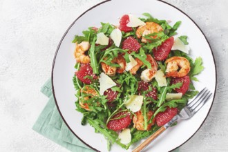 Fresh shrimp salad with arugula, grapefruit, and parmesan served in a bowl
