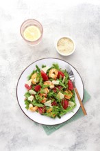 Fresh shrimp salad with arugula, grapefruit, and parmesan served in a bowl