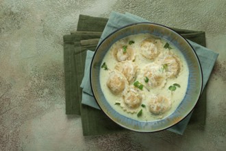 Ravioli in cream sauce, spices and herbs, top view, no people