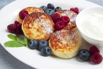 Breakfast, cottage cheese cakes, with fresh berries, and sour cream, top view, close-up, no people
