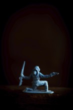 A cowboy figure is captured in a low stance, dynamically poised with two weapons