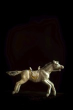 A detailed toy horse is captured in motion, showcasing its intricate design and craftsmanship. The