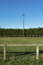 Rural football field surrounded by greenery and bright blue sky on a sunny day. Puy de Dome,