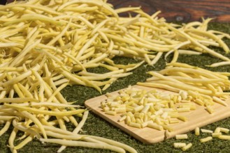 Yellow beans on a board, some sliced, surrounded by whole runner beans