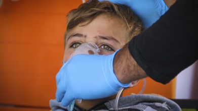 A doctor examines children's malnutrition inside a refugee camp