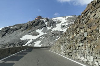 View in front of a narrow bend above the tree line in front of the Stelvio Alpine Pass road to the