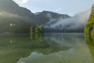 Mystical morning at Königssee in Schönau with boathouses and Christlieger. Sunrise and beautiful