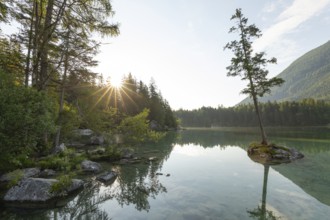 Summer morning at Hintersee near Ramsau in Berchtesgadener Land with sun star and reflection
