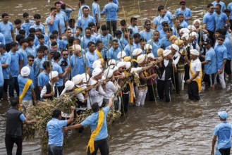 People from the Pnar community perform rituals as they using a tree to celebrate an event organised