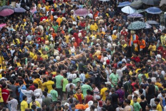 People from the Pnar community perform rituals as they carry a large log to celebrate an event