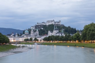 The city of Salzburg with the fortress on the Salzach shines in the first light of summer morning