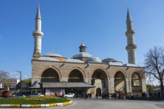 Historic mosque with two minarets on a busy street. The sky is sunny with clear blue. Old Mosque,