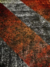 Bold red and black lines create an eye-catching pattern on a rough surface, illuminated by warm