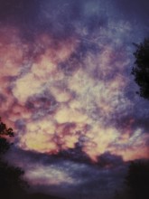 Colorful cotton candy clouds illuminate the twilight sky with vibrant hues of pink, purple, and