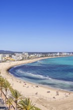 Aerial view at a sand beach with sunbathing tourists by a tourist resort by the sea a sunny summer