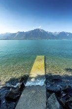 Montreux. A pier stretches out into the tranquil waters of Lake Geneva, surrounded by stunning