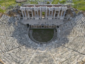 View of an ancient theatre with majestic ruins and surrounding green areas, amphitheatre, aerial