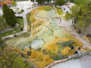 Natural terraces of mineral deposits with people in a green environment, aerial view, Karahayit