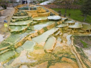 A geothermal landscape with mineral terraces and water accumulations, aerial view, Karahayit