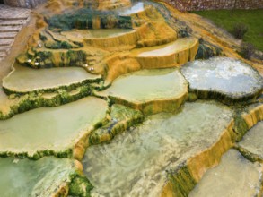 Natural mineral terraces with water accumulations and colourful rock formations, aerial view,