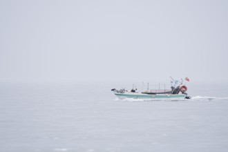 Fishing boat in the fog on the sea, Lagos, Algarve, Portugal