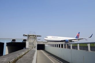 Aeroplane taxiing over a bridge over a road and cycle path, Amsterdam-Schiphol Airport, North