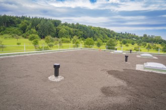 Green roof with several ventilation shafts and cloudy sky, roof greening, house construction,