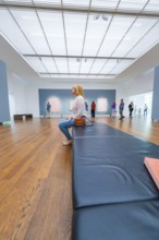 Visitors sit on a bench in a gallery and look at the works of art on display, Frieder Burda Museum,