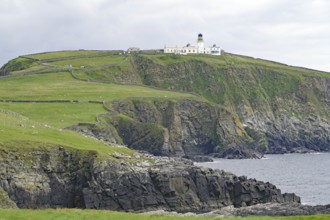 A lighthouse stands on high cliffs above a rough, cloudy coast, Sumburgh Head, Robert Louis