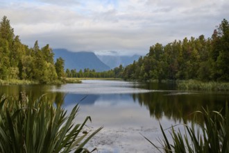 A calm lake with mountains in the background and a clear reflection in the water, summer, Lake