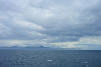 The wide sea under a cloudy sky with mountains in the distance, summer, Cook Strait, North Island,