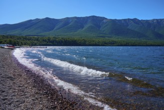 Beach with pebbles, waves crashing on the shore, peaceful mountain landscape, summer, Lake Rotoiti,