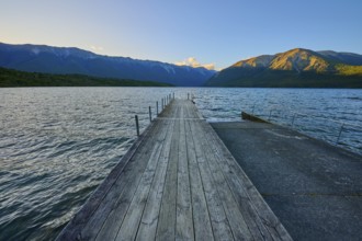 Wooden jetty at the lake with mountain landscape at dusk, summer, Lake Rotoiti, Saint Arnaud,