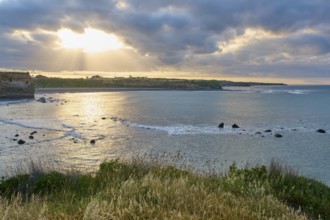 Waves on the coast under a dramatic sky, sunbeams breaking through the clouds, summer, Opunake,