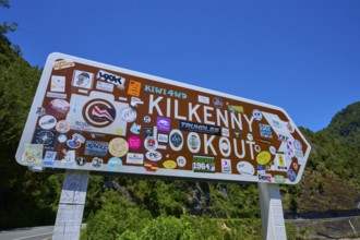 Sign at tourist lookout with various colourful stickers, Kilkenny Lookout, Lower Buller Gorge,