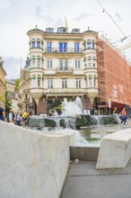 Historic building and bubbling fountain in a lively, urban neighbourhood, Baden Baden, Germany