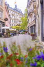 Lively street with cafés and flowers in the foreground, framed by historic buildings, Baden Baden,