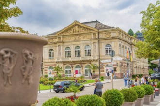 Magnificent historic building, surrounded by people and cars, surrounded by plants, Baden Baden,