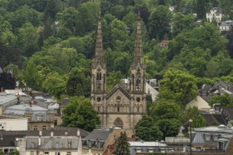Gothic church with high towers embedded in a wooded urban landscape, Baden Baden, Germany