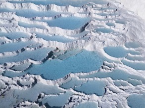 Close-up of turquoise-coloured water terraces surrounded by white limestone, aerial view, sinter